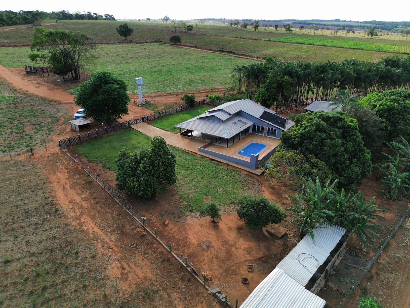Vista au00e9rea da casa, u00e1reas externas e acesso interno da chu00e1cara.