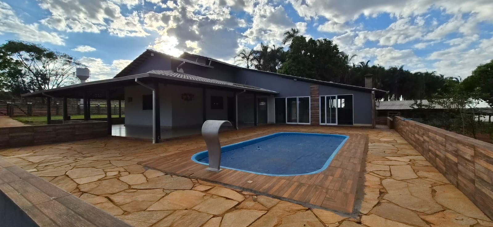 u00c1rea da piscina e varanda da casa principal.