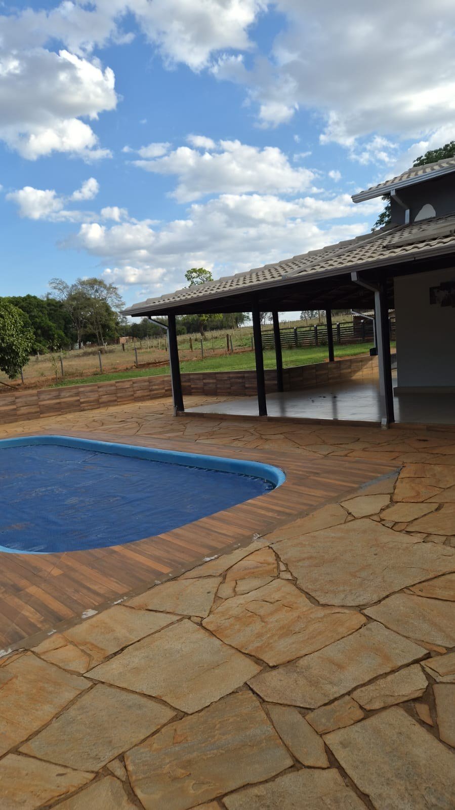 Piscina da propriedade com u00e1rea de lazer ao redor.